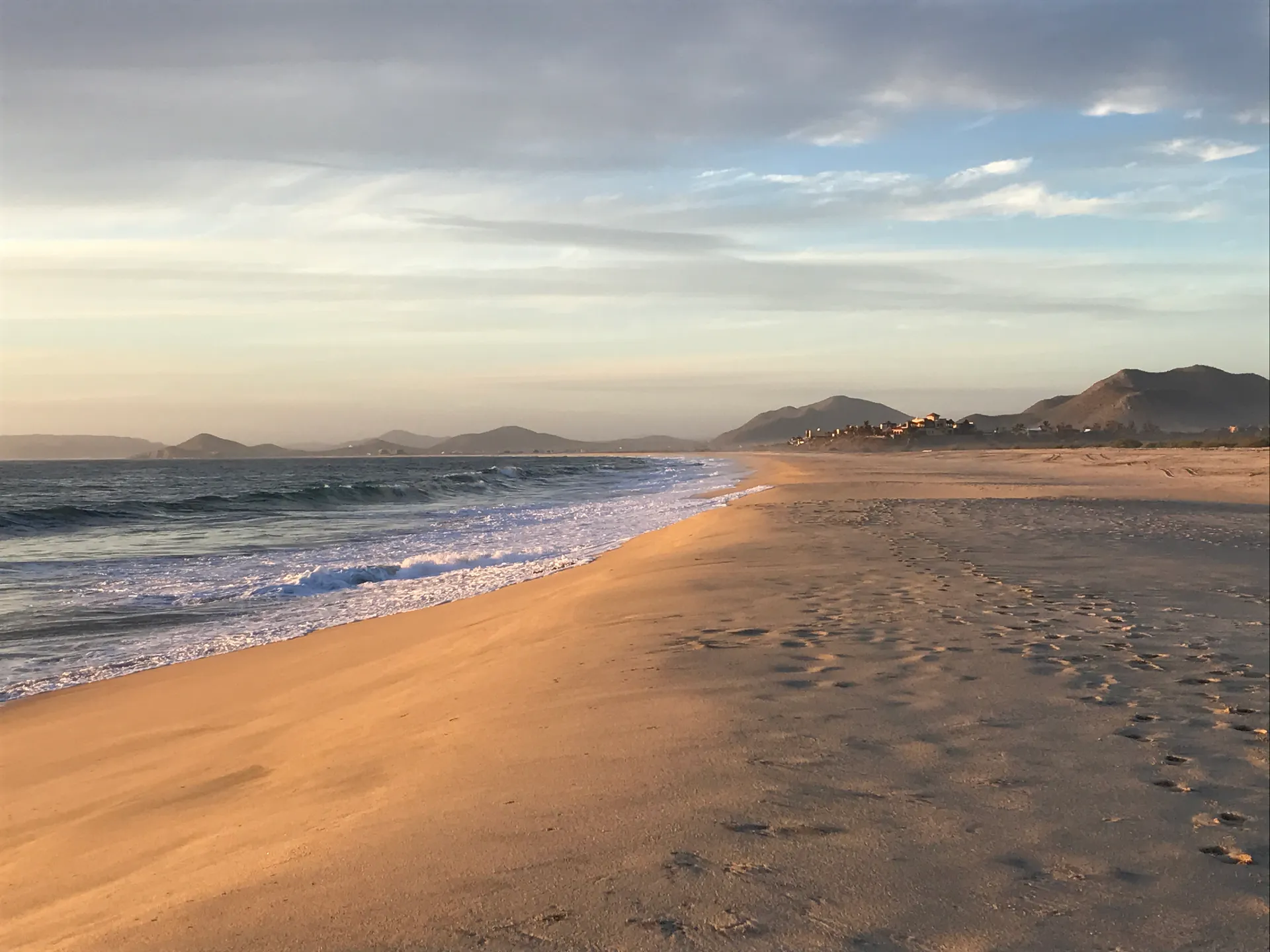 A wide empty beach with soft evening light