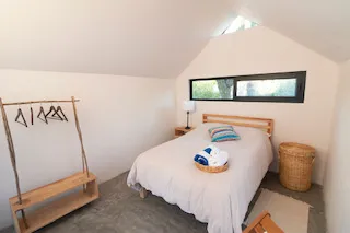 A simple, quiet guest room with a made bed at the Ceremonia Baja California retreat